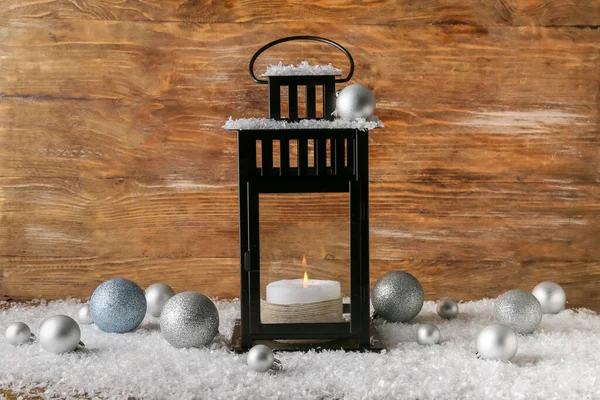 Schöne Weihnachtslaterne Mit Kerze Kugeln Und Schnee Auf Holzgrund — Stockfoto