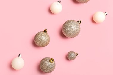 Pembe arka planda farklı parlak noel baloları