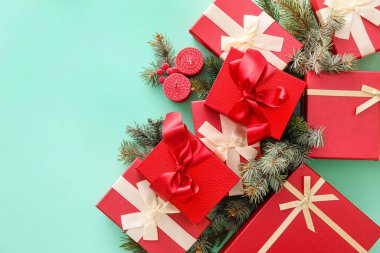 Renkli arkaplanda Noel hediyesi kutuları, mumlar ve köknar dallarıyla kompozisyon