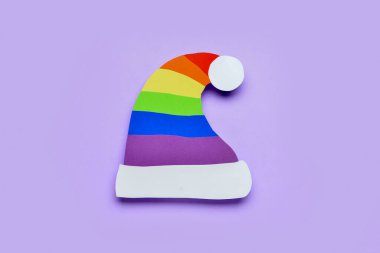 Arka planda gökkuşağı kağıtlı Noel Baba şapkası. LGBT kavramı