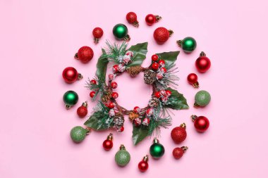 Noel çelengi ve pembe arka planda süslemeleri olan kompozisyon