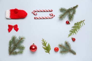 Beyaz arkaplanda kozalaklı dallardan ve dekorasyonlardan oluşan çerçeve