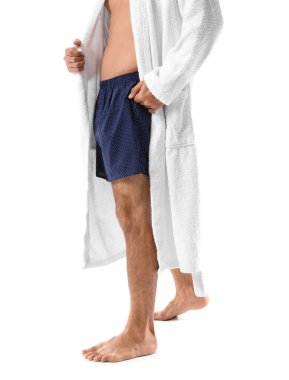 Beyaz arka planda iç çamaşırlı ve bornozlu yakışıklı bir genç.