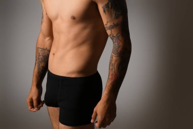 Gri arka planda iç çamaşırlı yakışıklı bir genç.