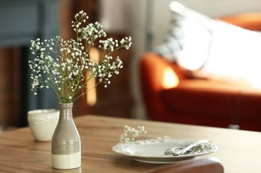 Yemek masasının üzerinde çingene çiçekleri olan vazo, yakın plan.