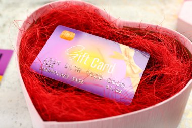 Hediye kartıyla açılmış kalp şeklinde bir kutu, yakın plan.