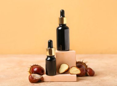 Renkli arka planda gerekli yağ şişeleri ve taze kestaneler ile kompozisyon