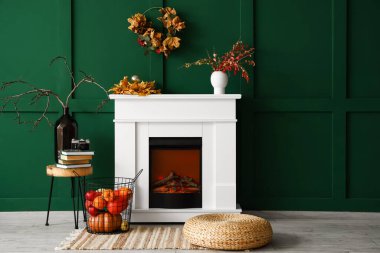 İçinde şömine, balkabağı ve yapraklar olan modern bir oda.