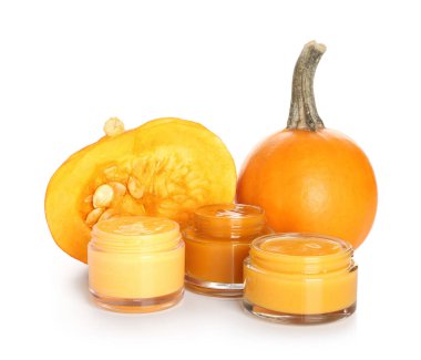 Doğal maske kavanozları ve beyaz arka planda olgun balkabakları