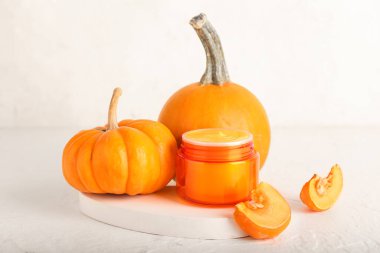 Doğal maske kavanozu ve arka planda olgun balkabakları.