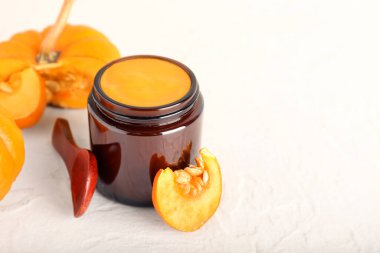 Açık arkaplanda doğal kabak maskeli kavanoz.