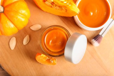 Ahşap arka planda doğal balkabağı maskesi kavanozları, yakın plan.