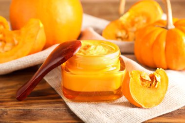 Kavanoz ve doğal balkabağı maskesi ahşap masada, yakın plan.