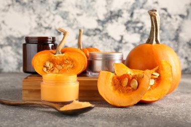 Doğal maske kavanozları ve grunge arkaplanda olgun balkabaklarıyla kompozisyon