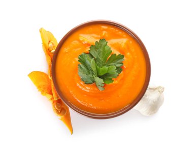 Beyaz arka planda bir kase lezzetli balkabağı kremalı çorba.