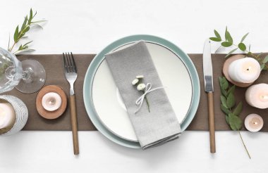 Beyaz arkaplanda yanan mumlarla güzel masa ayarları