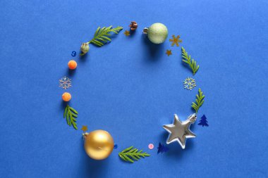 Köknar dallarından yapılmış çerçeve ve mavi arkaplanda Noel dekoru