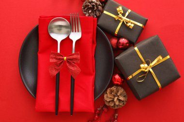 Kırmızı arka planda dekor ve hediye kutularıyla güzel bir Noel masası.