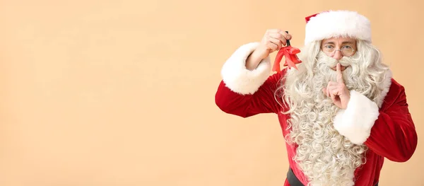 Weihnachtsmann Mit Weihnachtsglocke Mit Geste Der Stille Auf Beigem Hintergrund — Stockfoto