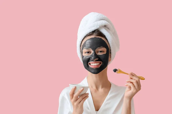 Junge Frau Trägt Aktivkohlemaske Auf Ihrem Gesicht Vor Farbigem Hintergrund — Stockfoto