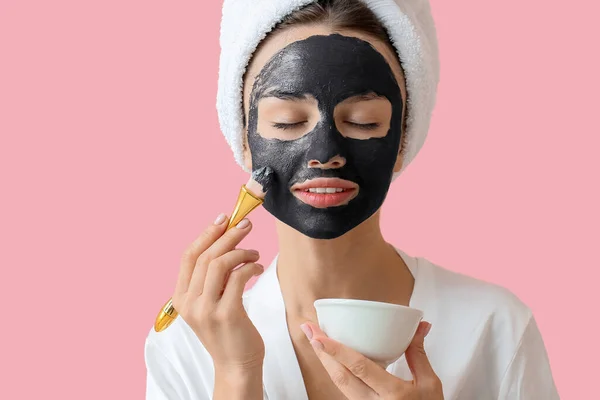 Mladá Žena Která Používá Aktivní Uhlí Masku Tváři Barevném Pozadí — Stock fotografie