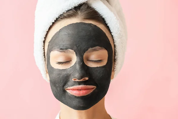 Ung Kvinna Med Aktiverat Kol Mask Ansiktet Mot Färg Bakgrund — Stockfoto