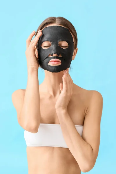 Jonge Vrouw Met Geactiveerde Houtskool Masker Haar Gezicht Tegen Kleur — Stockfoto