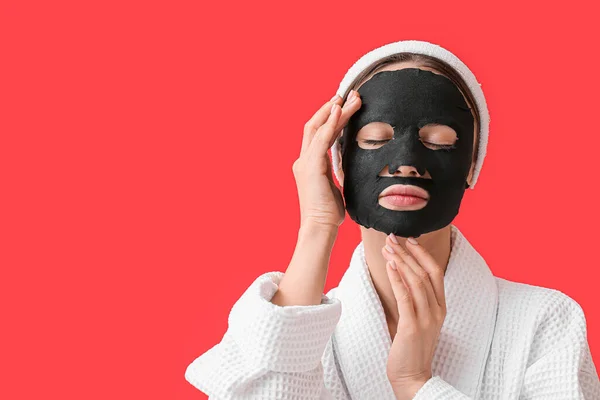 Jonge Vrouw Met Geactiveerde Houtskool Masker Haar Gezicht Tegen Kleur — Stockfoto