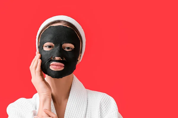 Jonge Vrouw Met Geactiveerde Houtskool Masker Haar Gezicht Tegen Kleur — Stockfoto