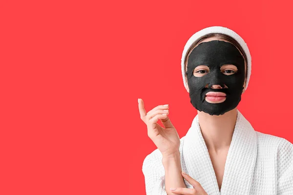 Jonge Vrouw Met Geactiveerde Houtskool Masker Haar Gezicht Tegen Kleur — Stockfoto