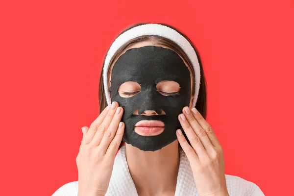 Ung Kvinna Med Aktiverat Kol Mask Ansiktet Mot Färg Bakgrund — Stockfoto