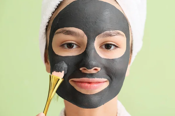 Jonge Vrouw Met Geactiveerde Houtskool Masker Haar Gezicht Tegen Kleur — Stockfoto