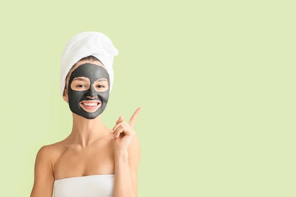 Young Woman Activated Charcoal Mask Her Face Pointing Something Color — Stock Photo, Image