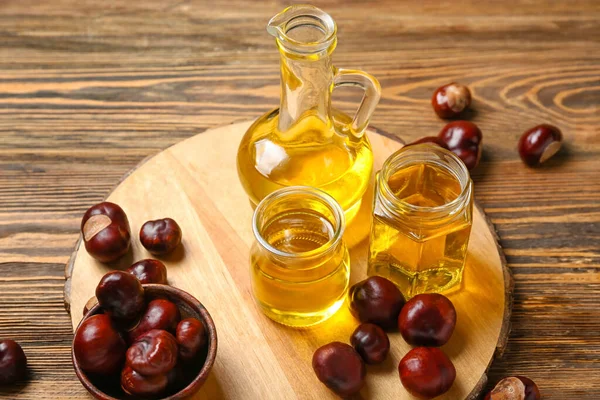 Board Bottles Essential Oil Fresh Chestnuts Wooden Background Closeup — Stock Photo, Image