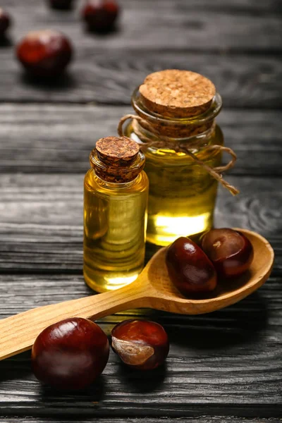 Bottles Essential Oil Spoon Chestnuts Dark Wooden Background Closeup — Stock Photo, Image