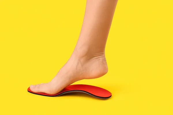 Ženské Nohy Červené Ortopedické Stélky Žlutém Pozadí — Stock fotografie