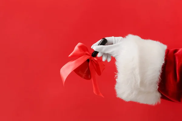 Santa Hand Med Julen Klocka Röd Bakgrund — Stockfoto