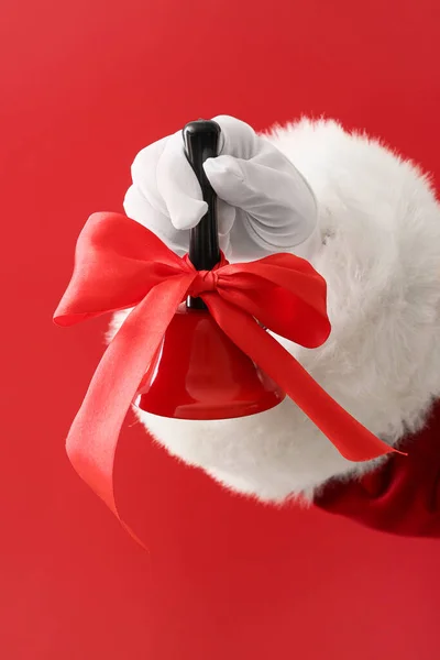 Santa Hand Med Julen Klocka Röd Bakgrund — Stockfoto