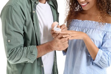 Genç adam beyaz arka planda kız arkadaşına evlenme teklif ediyor.