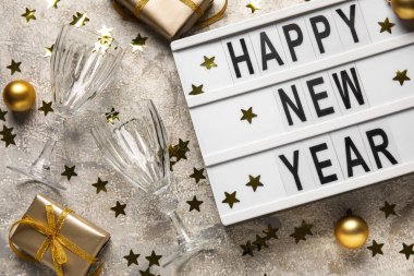 Yeni Yıl, Gözlükler, hediye kutuları ve gri arkaplanda konfeti, yakın plan.