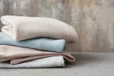 Grunge arka planında farklı rahat süveterler yığını