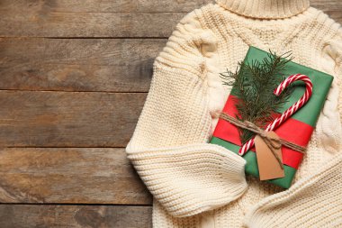 Sıcak süveter ve Noel hediyesi ahşap arka planda