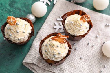 Lezzetli kekler ve yeşil arka planda Noel topları.