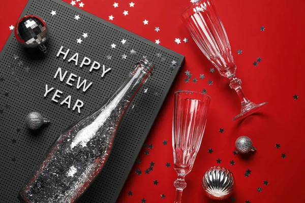 Kırmızı Arka Planda Mutlu Yıllar Yazılı Pano Şampanya Şişesi Bardak — Stok fotoğraf