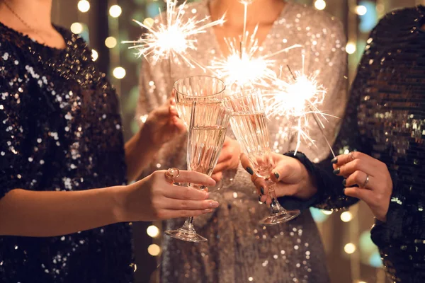 Ženy Elegantních Šatech Vánočními Světly Sklenicemi Šampaňského Detailní Záběr — Stock fotografie