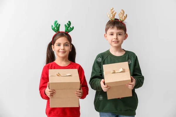 Lustige Kleine Kinder Mit Rentierhörnern Und Weihnachtsgeschenken Auf Hellem Hintergrund — Stockfoto