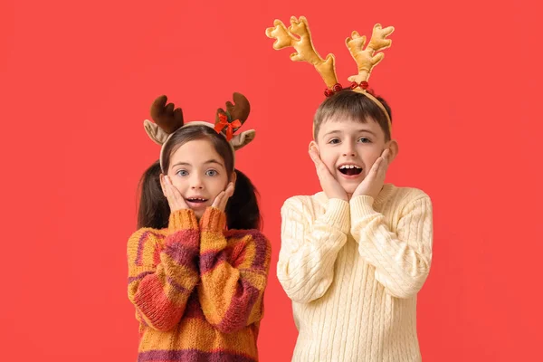 Überraschte Kleine Kinder Mit Rentierhörnern Auf Farbigem Hintergrund — Stockfoto