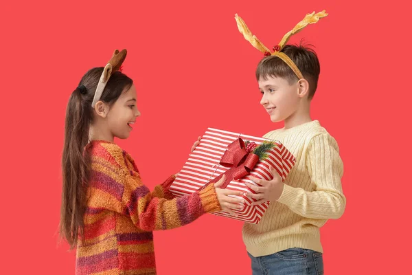 Lustige Kleine Kinder Mit Rentierhörnern Und Weihnachtsgeschenk Auf Farbigem Hintergrund — Stockfoto
