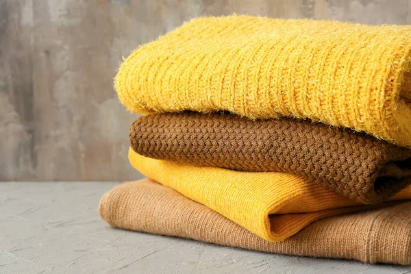 Stack Different Cozy Sweaters Grunge Background — Stock Photo, Image