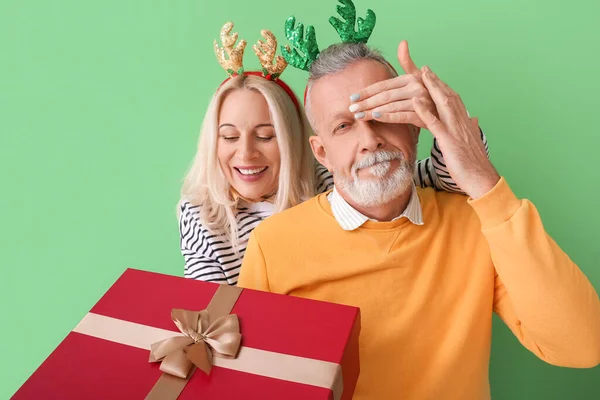 Glad Mogen Kvinna Hälsar Sin Man Julafton Mot Färg Bakgrund — Stockfoto